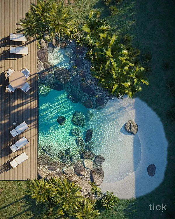 Small tropical pool with natural rock edge and palm trees