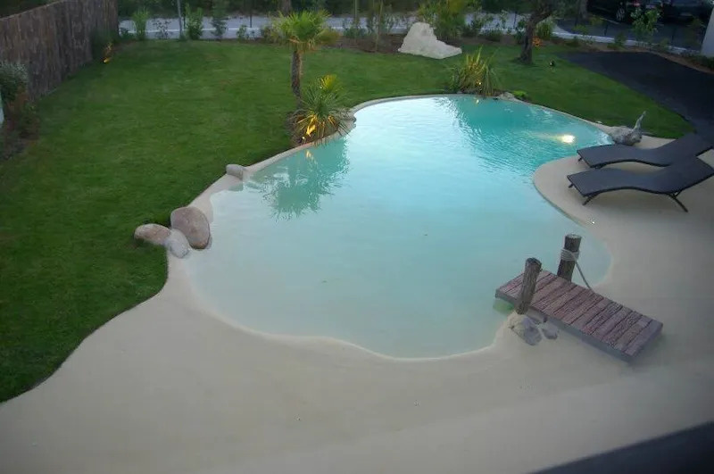 Crystal-clear tropical pool with beach entry and surrounding garden